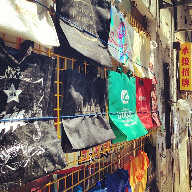 #bags lined up on a #wall on the #street. For sale? Nope, they're proof of works / #advertisement for the printing company within. #hongkong #hk #hkig