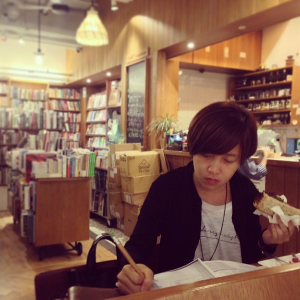 Kubrick #cafe in #YauMaTei - a #bookstore cum cafe attached to an arthouse cinema. Here, a #lady has a #sandwich while jotting notes.