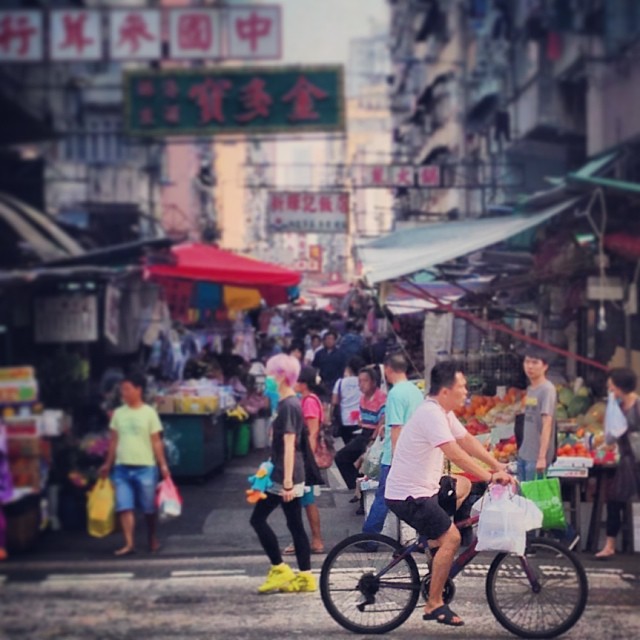 Generations in Passing - a young #lady and an old #cyclist pass each other in front of a #street #market in #mongkok. #hk #hongkong #hkig