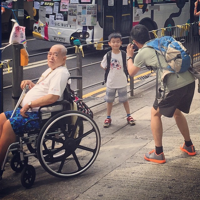 A sea of humanity at the #OccupyHK protest in #Mongkok - young and old, able and disabled, serious and bystanders. Here an old disabled man sits by the roadside while a father and son combo snap pictures in the background. #HongKong #hk #hkig