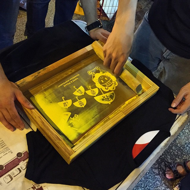 At #OccupyHK #Mongkok tonight - free #silkscreening of protest #tshirts. Bring your own tee, they provide the #silkscreen and ink. Queue up and voila, you got your own protest #tee. #HongKong #hk #hkig