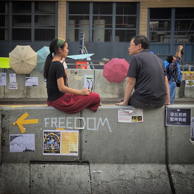 Dialogue is the way to #Freedom - a lady and a man sit on a highway divider in #Admiralty, deep in discussion about #OccupyHK. #HongKong #hk #hkig