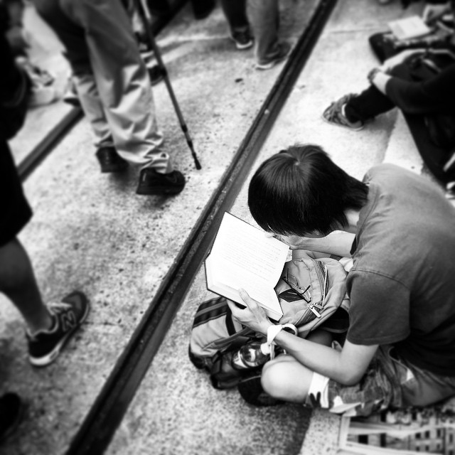 Even as #protesters march past during #OccupyHK, some found the time to #read. Actually, lots of people were seated reading. These protesters are probably the most well-read demonstrators ever. #mono #HongKong #hk #hkig
