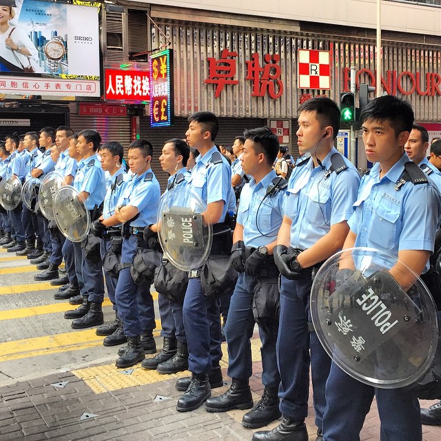 #HongKong #police holding the line on #ShantungStreet in #Mongkok. To be honest, I don't know what they're holding the line against. The crowd here is mainly press and onlookers. #OccupyHK protesters? Just a handful and they're just milling around, totally non-confrontational. Feels more like a press photo op at the moment. #HK #hkig #thinblueline