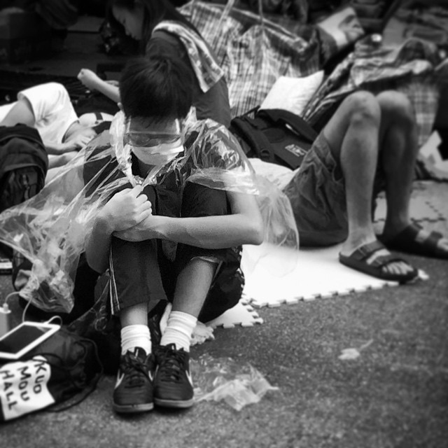 An #OccupyHK #protester sitting on #NathanRoad in #Mongkok, ready for battle with #goggles, #facemask and plastic #cape. #mono #HongKong #hk #hkig