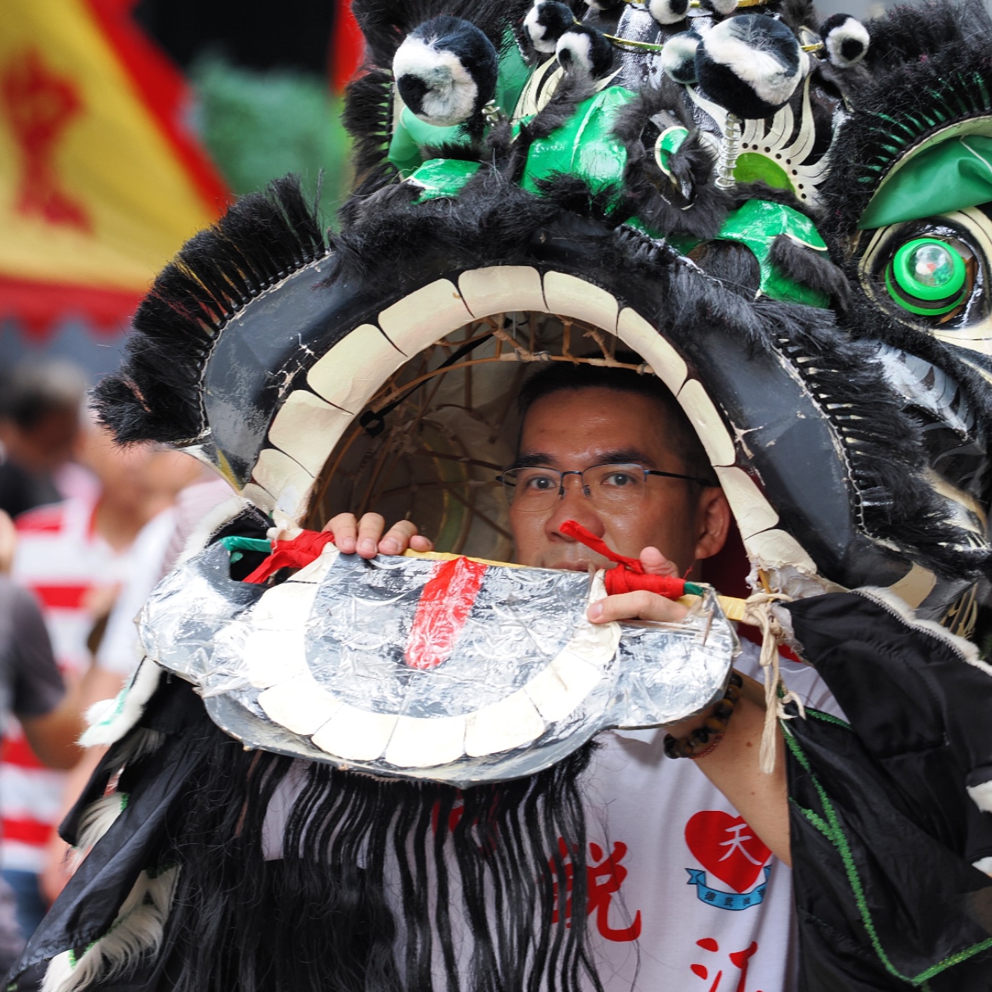 Tam Kung Birthday Parade in Shau Kei Wan – a Lion Dancer peaks out of the Lion’s head during a Lion Dance. hongkong hk hkig shaukeiwan tamkung parade liondance