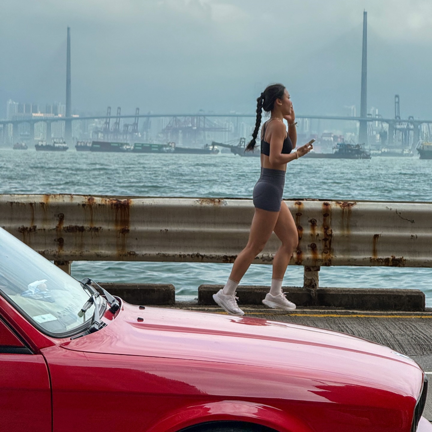 That Kennedy Town Life – a female runner along the praya, phone in hand. hongkong hk hkig kennedytown runner