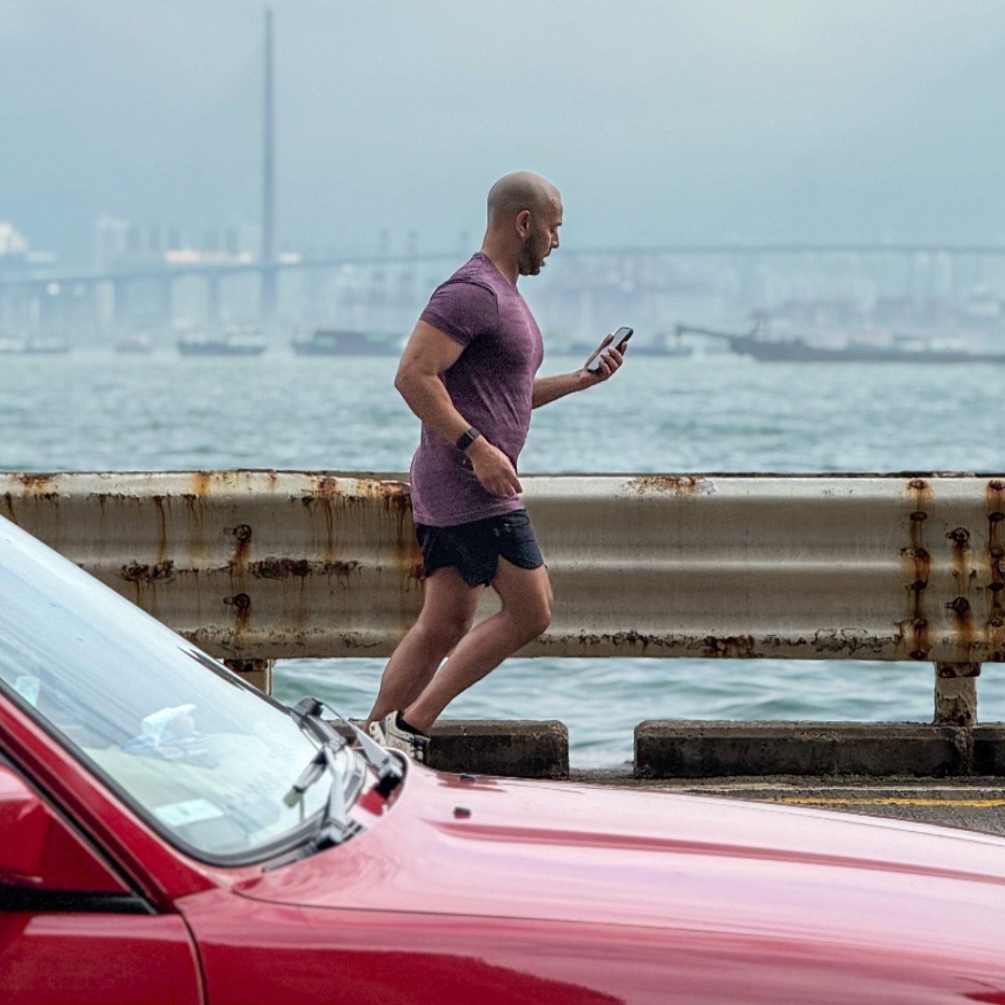That Kennedy Town Life – a man running and checking his phone on the praya. hongkong hk hkig kennedytown runner