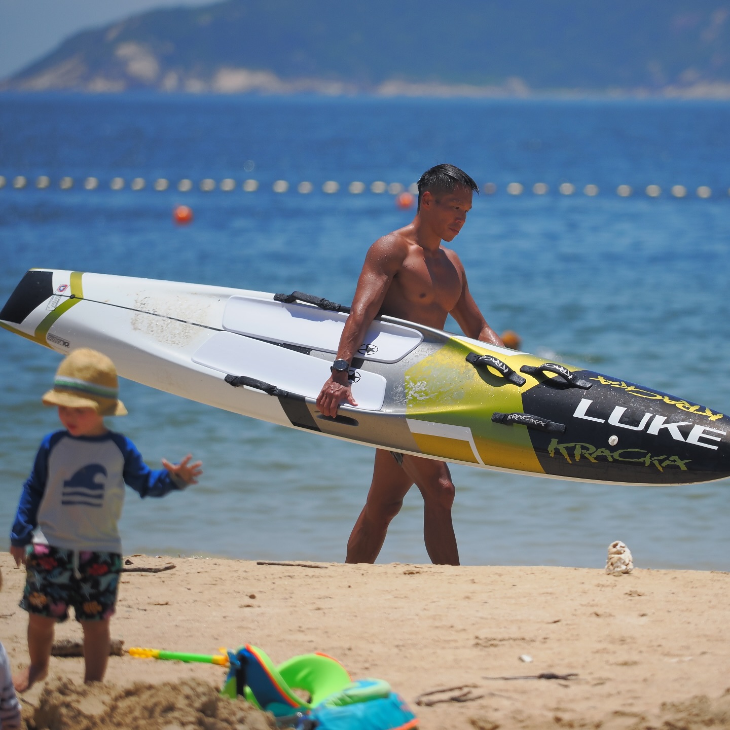 Summer in Hong Kong. A tanned man carries his kayak on Shek O beach. hongkong hk hkig beach summer kayak shekobeach sheko