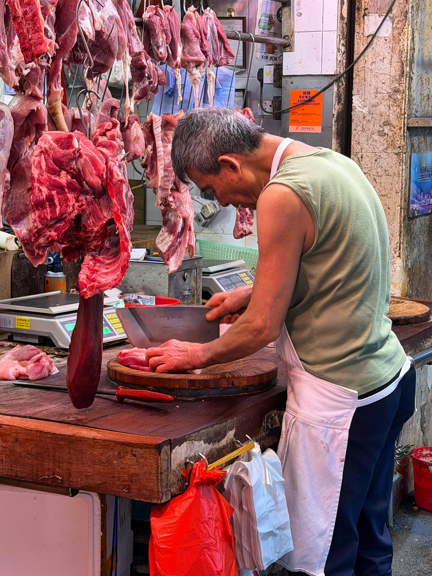 A butcher at the North Point street market. hongkong hk hkig northpoint butcher meat streetmarket