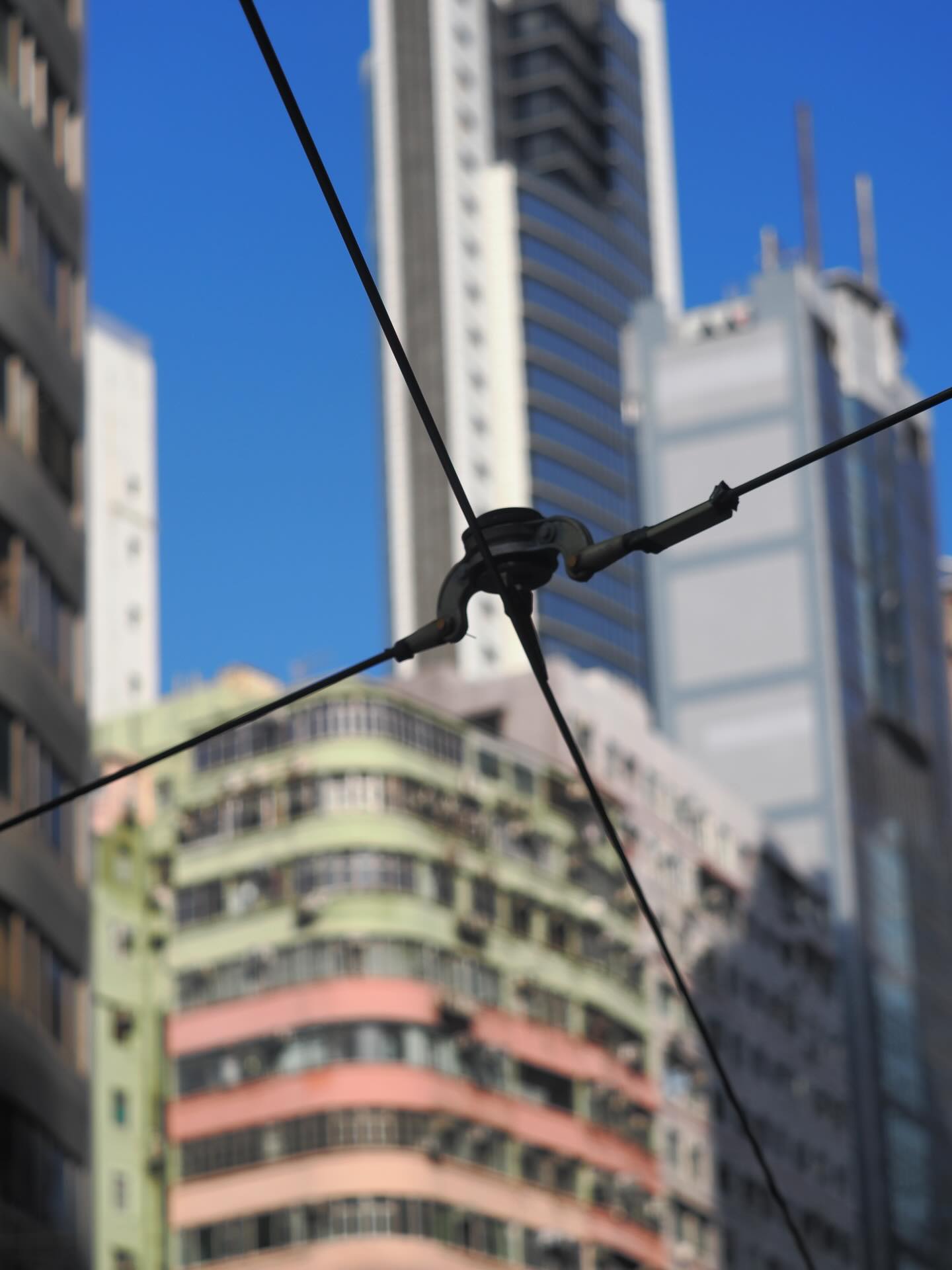 Quartered. The power lines for the HK tram quarters the view of a Tong Lau and modern buildings. hongkong hkig buildings tonglau hktramways